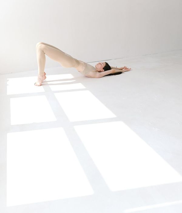 Woman in a calm yoga pose in a bright studio environment.